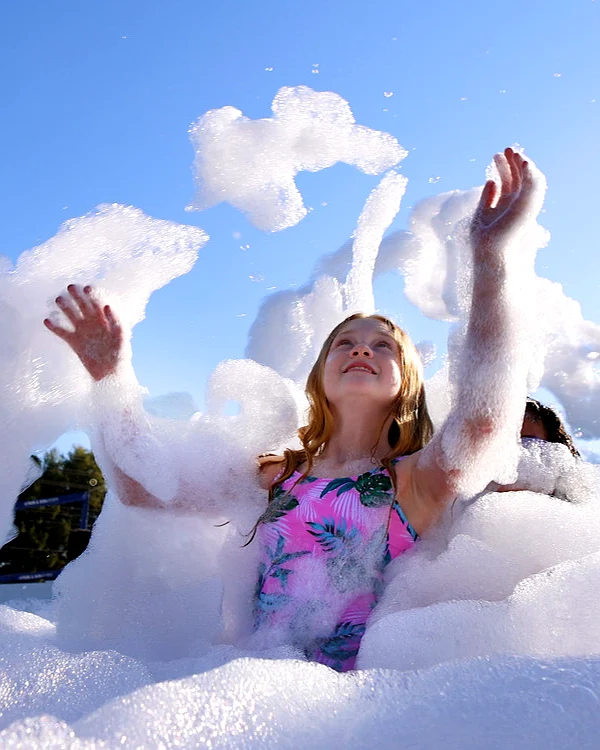 A girl playing in a cloud of party foam