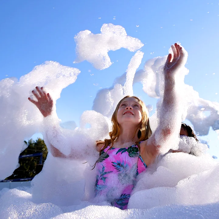 A girl playing in a cloud of foam at a Bounce On foam party